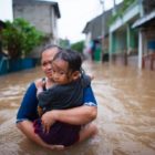 Woman, child walk through Jakarta floodwaters